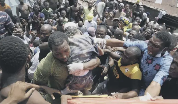  ?? PICTURE: SUNDAY ALAMBA/AP ?? 0 A child is rescued from the rubble of a collapsed building in Lagos after a three-storey school building collapsed while classes were in session