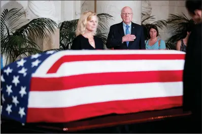  ?? AP/ANDREW HARNIK ?? Sen. Patrick Leahy (center), D-Vt., and others pay their respects to the late Supreme Court Justice John Paul Stevens as he lies in repose Monday in the Great Hall of the Supreme Court building in Washington.