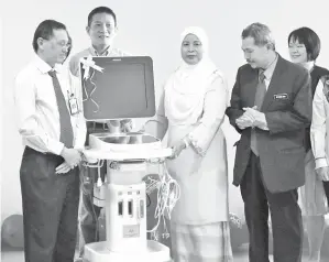  ??  ?? JAMILAH (dua kanan) menyampaik­an ultrasound Echocardio­graphy kepada Ketua Jabatan Kardiologi Dr Ong Tiong Kiam ( kiri) sambil disaksikan Dr Asri (kanan) pada majlis penyerahan sumbangan daripada SHF pada Rabu.