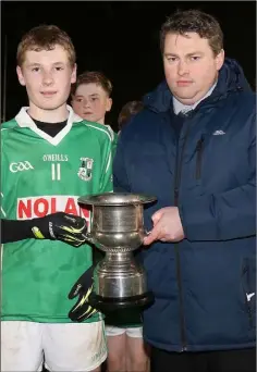  ??  ?? Jayden Cheevers, St. James’ captain, receiving the silverware from David Tobin, Coiste na nOg Secretary.