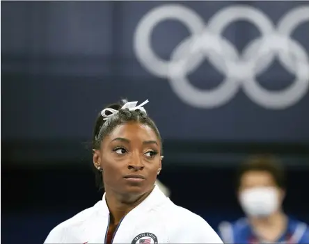  ?? ASHLEY LANDIS, FILE — THE ASSOCIATED PRESS ?? In this July 27, 2021file photo, Simone Biles, of the United States, watches gymnasts perform after she exited the team final at the 2020 Summer Olympics, in Tokyo. Biles and Naomi Osaka are prominent young Black women under the pressure of a global Olympic spotlight that few human beings ever face. But being a young Black woman -- which, in American life, comes with its own built-in pressure to perform -- entails much more than meets the eye.