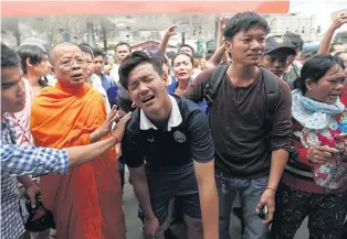  ?? REUTERS ?? People comfort a relative of Kem Ley, anti-government figure and the head of a grassroots advocacy group, “Khmer for Khmer” outside a gas station after he was shot dead in Phnom Penh yesterday.