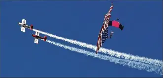  ?? TY GREENLEES / STAFF ?? Team Red Line flies circles around the Misty Blues flag jump at the Vectren Dayton Air Show on Saturday. For more on the Misty Blues, see Page B5.