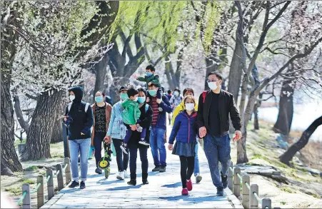  ?? ZOU HONG / CHINA DAILY ?? All wearing face masks, tourists flock to the Summer Palace in Beijing to enjoy the flowers on March 22.