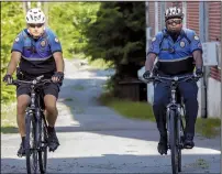  ?? Arkansas Democrat-Gazette/JOHN SYKES JR. ?? Officer Kelley Crace (left) and Sgt. Van Watson pedal through an alley near 12th and Cedar streets in Little Rock. The bike patrol often rides 10 to 15 miles a day.