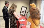  ?? Spencer Lahr / RN-T ?? Lee Taylor (right) and Scott Morris, the son of Annette Morris, a 2018 Heart of the Community Award recipient, look over silent auction items before the banquet.