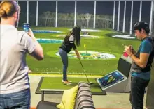  ?? Topgolf ?? A golfer aims at a target at a Topgolf complex.