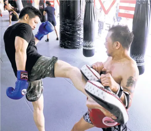  ??  ?? Businessma­n Chatri Sityodtong, left, attends a Muay Thai training session.