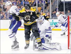  ?? AP PHOTO ?? Toronto Maple Leafs goaltender Curtis McElhinney makes a save as Boston Bruins’ Patrice Bergeron and defenseman Travis Dermott battle for position during the second period of Game 2 of an NHL hockey first-round playoff series in Boston, Saturday.