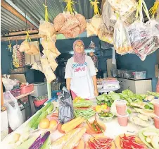  ?? ?? Like Mohammad, Muraini also owns and runs a sundry shop in Kampung Semarang.