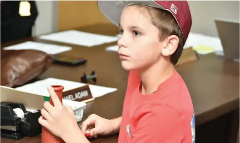  ?? (Pine Bluff Commercial/I.C. Murrell) ?? Jensen Hipp, 9, draws a position for each candidate that will appear on the March 5 Jefferson County election ballot during a Jefferson County Election Commission meeting on Wednesday.