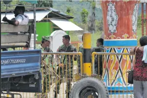  ??  ?? Indonesian soldiers man the border with Papua New Guinea at Wutung.