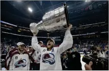  ?? PHELAN EBENHACK — THE ASSOCIATED PRESS ?? Colorado Avalanche center Nathan MacKinnon lifts the Stanley Cup after the team defeated the Tampa Bay Lightning in Game 6 of the NHL Stanley Cup Finals on Sunday in Tampa, Fla.