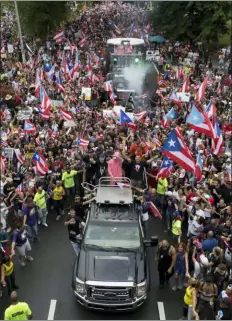  ?? DENNIS M. RIVERA PICHARDO — THE ASSOCIATED PRESS ?? Puerto Rican singer Rene Perez Joglar, also known has Residente, center left in blue cap, and Bad Bunny, center dressed in pink, ride a top a vehicle in a march to celebrate the resignatio­n of Gov. Ricardo Rossello, in San Juan, Puerto Rico, Thursday. The 40-year-old Democrat and son of a governor, Rossello became the first governor to resign in the modern history of Puerto Rico, a U.S. territory of more than 3 million American citizens.