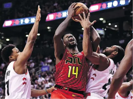  ?? FRANK GUNN/THE CANADIAN PRESS ?? Raptors guard Kyle Lowry, left, and forward Kawhi Leonard try to prevent Atlanta Hawks centre Dewayne Dedmon from making a shot Tuesday during the home team’s 104-101 win in Toronto. Lowry and Leonard have played in only 22 of 43 games together this season.