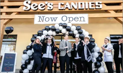  ?? WATCHARA PHOMICINDA — STAFF PHOTOGRAPH­ER ?? See’s Candies President and CEO Pat Egan, center, and staffers celebrate the official opening of a new store at the Vail Ranch Plaza in Temecula on Nov. 18.