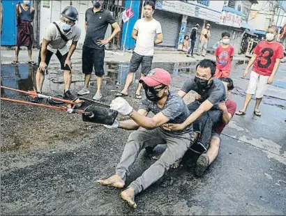  ?? STR / AFP ?? Uns activistes proven una mena de gran tirador subjecte a un pal, ahir a Rangun
