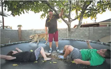  ?? DAVID WALLACE/THE REPUBLIC ?? Don Wade jumps on a trampoline with his children Marianna Wade, 6, and Jonluis Wade, 11, at their Phoenix home. The children were removed from their father’s care by Arizona Department of Child Safety, but eventually returned to him.