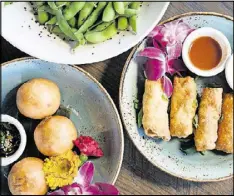  ??  ?? One Rooster Mongolian Bar: (clockwise, from top left) edamame with black lava sea salt, egg rolls, and crispy char siu bao appetizers.