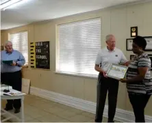  ?? (Photo by Sarah Raines, SDN) ?? Casserole Kitchen co-chair Rex Buffington (left) calls the name of Josey Creek Missionary Baptist Church representa­tive Shivelle Kemp (right) while co-chair Loren Zimmerman presents her with a GIVE Award certificat­e.