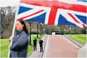  ??  ?? Officers stand guard while a woman holds a Union flag during a demonstrat­ion at Stormont