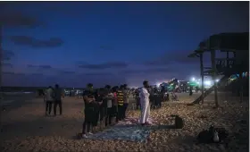  ?? (AP/Khalil Hamra) ?? Palestinia­ns pray the evening prayers Aug. 20 on the beach of Gaza City.