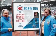  ?? KATHY WILLENS/AP PHOTO ?? Rachel Robinson, left, widow of Jackie Robinson, and daughter Sharon pose for a photograph with a plaque honoring Jackie on Jackie Robinson Day prior to Sunday’s game between the Mets and Brewers at New York.