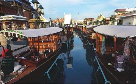  ?? Arshad Ali/Gulf News ?? Floating on the canal by the Far East Asia pavilion at the Global Village, each kiosk boat offers its own speciality food and drink.