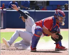  ?? JON BLACKER – THE CANADIAN PRESS VIA AP ?? The Yankees' Isiah Kiner-Falefa scores a fourth-inning run on a bases-loaded double by Aaron Hicks as Blue Jays catcher Alejandro Kirk fields the throw on Saturday in Toronto.