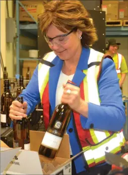  ?? ANDREA PEACOCK/The Daily Courier ?? Premier Christy Clark boxes wine bottles during a campaign stop at Gray Monk EstateWine­ryinLakeCo­untryonWed­nesday.Theprovinc­ialelectio­nisMay9.