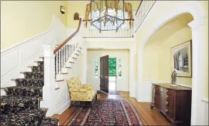  ??  ?? The first introducti­on to the home is made in the entry foyer, with elegant molding, wainscotti­ng, an arched alcove and warm honey-hued hardwood flooring.