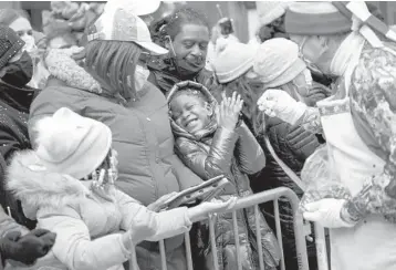  ?? ANNA WATTS/THE NEW YORK TIMES ?? Tamonai Skinner, 5, reacts after a clown tosses confetti her way Thursday during the Macy’s Thanksgivi­ng Day Parade in New York. The parade, complete with giant balloons steered down city streets, was back in full swing. With no COVID-19 vaccines and a surge in cases last Thanksgivi­ng, the parade was limited to one city block.