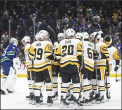  ?? The Canadian Press via AP ?? Pittsburgh Penguins players celebrate Erik Karlsson’s overtime goal as Vancouver Canucks goalie Thatcher Demko, left, skates off the ice during an NHL hockey game on Tuesday, in Vancouver, British Columbia.