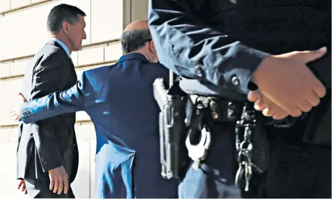  ??  ?? Michael Flynn, Mr Trump’s former national security adviser and staunch ally, is escorted into court for his plea hearing. Left, Flynn with Trump on the campaign trail in October 2016