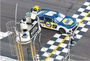  ?? The Associated Press ?? NASCAR Cup Series driver Chase Elliott (9) takes the checkered flag under a yellow caution flag at a NASCAR Cup Series race at Atlanta Motor Speedway in Hampton, Ga., Sunday.