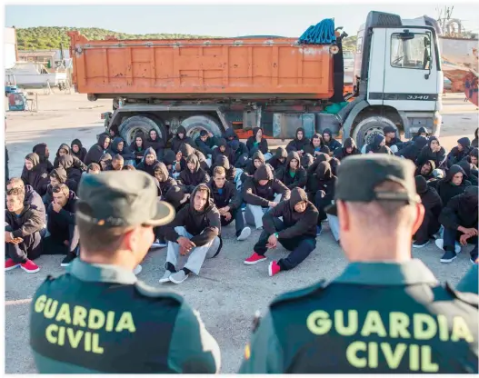  ??  ?? Moroccan migrants sit at the port of Barbate after being rescued in the Strait of Gibraltar off the Spanish coast on Friday. (AFP)