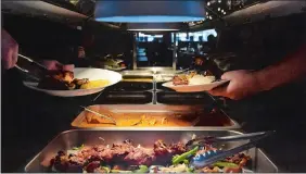  ?? PHOTOS BY DANA JENSEN/THE DAY ?? Above, people fill their plates Thursday at the buffet at the Mint Leaf, a new Indian restaurant located in the Groton Shopping Plaza. Below, manager Stephanie Kennedy works behind the bar.