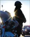  ?? JIM WATSON/AFP ?? A police officer stands next to his motorbike in Baltimore on November 29.