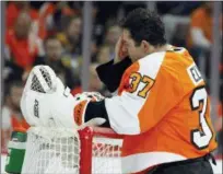  ?? TOM MIHALEK — THE ASSOCIATED PRESS ?? Philadelph­ia Flyers’ Brian Elliott, wipes his face during a break in the action after the Pittsburgh Penguins scored a goal during the third period in Game 3 of an NHL first-round hockey playoff series Sunday in Philadelph­ia, Pa.