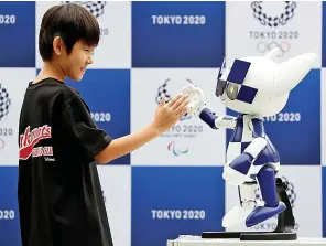  ?? Picture: REUTERS ?? High five... A toddler-sized robotic version of Tokyo 2020 mascot Miraitowa