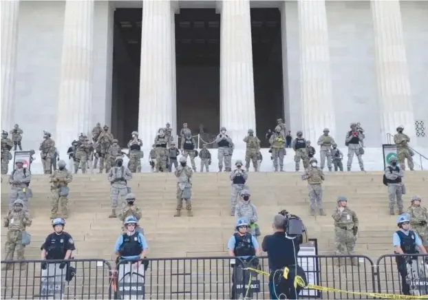  ?? (James Harnett/Social Media via Reuters) ?? LAW ENFORCEMEN­T personnel stand guard on the steps of the Lincoln Memorial on Tuesday as protests spread across US cities in reaction to the death of George Floyd in Minneapoli­s police custody.