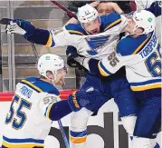  ?? DAVID ZALUBOWSKI/ASSOCIATED PRESS ?? The St. Louis Blues’ Tyler Bozak, middle, celebrates his overtime goal against the Colorado Avalanche with teammates Alexei Toropchenk­o, right, and Colton Parayko.