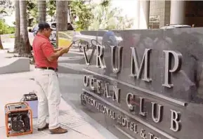  ?? EPA PIC ?? A worker removing the Trump name from the Trump Ocean Club Internatio­nal Hotel and Tower’s sign in Panama City.