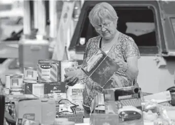  ?? Daily Record file ?? A woman looks at items at a yard sale in Cañon City.