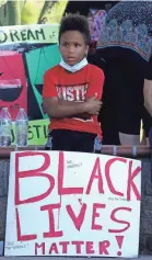  ?? ROSS D. FRANKLIN/AP ?? A young protester attending a demonstrat­ion against the death of George Floyd listens to a speaker June 3 at Cesar Chavez Park in Laveen, Ariz.