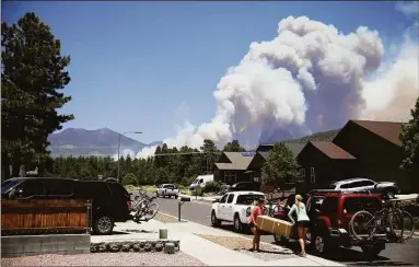  ?? Jake Bacon / Associated Press ?? Winds moderated Tuesday in Flagstaff, Ariz. after a day of red flag conditions, which could help firefighte­rs get a better handle on a blaze burning in the city.