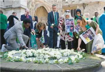  ?? JONATHAN BRADY/POOL PHOTO VIA GETTY ?? People create a circle of white roses during a memorial service Tuesday at London’s Westminste­r Abbey to remember the 72 victims of the Grenfell fire. Early on June 14, 2017, a fire broke out in the 24-story apartment building in North Kensington. The fire
spread to all floors and burned for 60 hours due to the building’s exterior cladding.