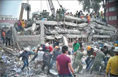  ?? YURI CORTEZ / AFP ?? Rescuers, firefighte­rs, police officers, soldiers and volunteers search for survivors in a flattened building in Mexico City on Wednesday, the day after a strong earthquake hit south-central Mexico. The magnitude 7.1 quake shook Mexico City on Tuesday,...