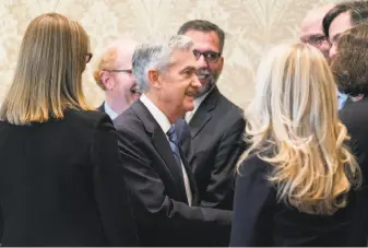  ?? Andrew Harrer / Bloomberg ?? Jerome Powell (center), new chairman of the U.S. Federal Reserve, meets with attendees after being sworn in on Monday. His approach to monetary policy is a bit of a mystery.