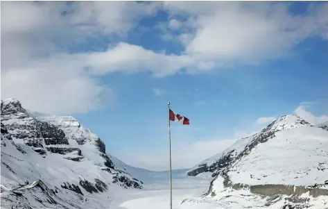  ?? THE CANADIAN PRESS FILES ?? The Canadian flag flies over the Columbia Icefields’ Athabasca Glacier in Jasper National Park. Nearly half the incidents of nudity that Parks Canada wardens dealt with in 2015 took place in Jasper National Park.